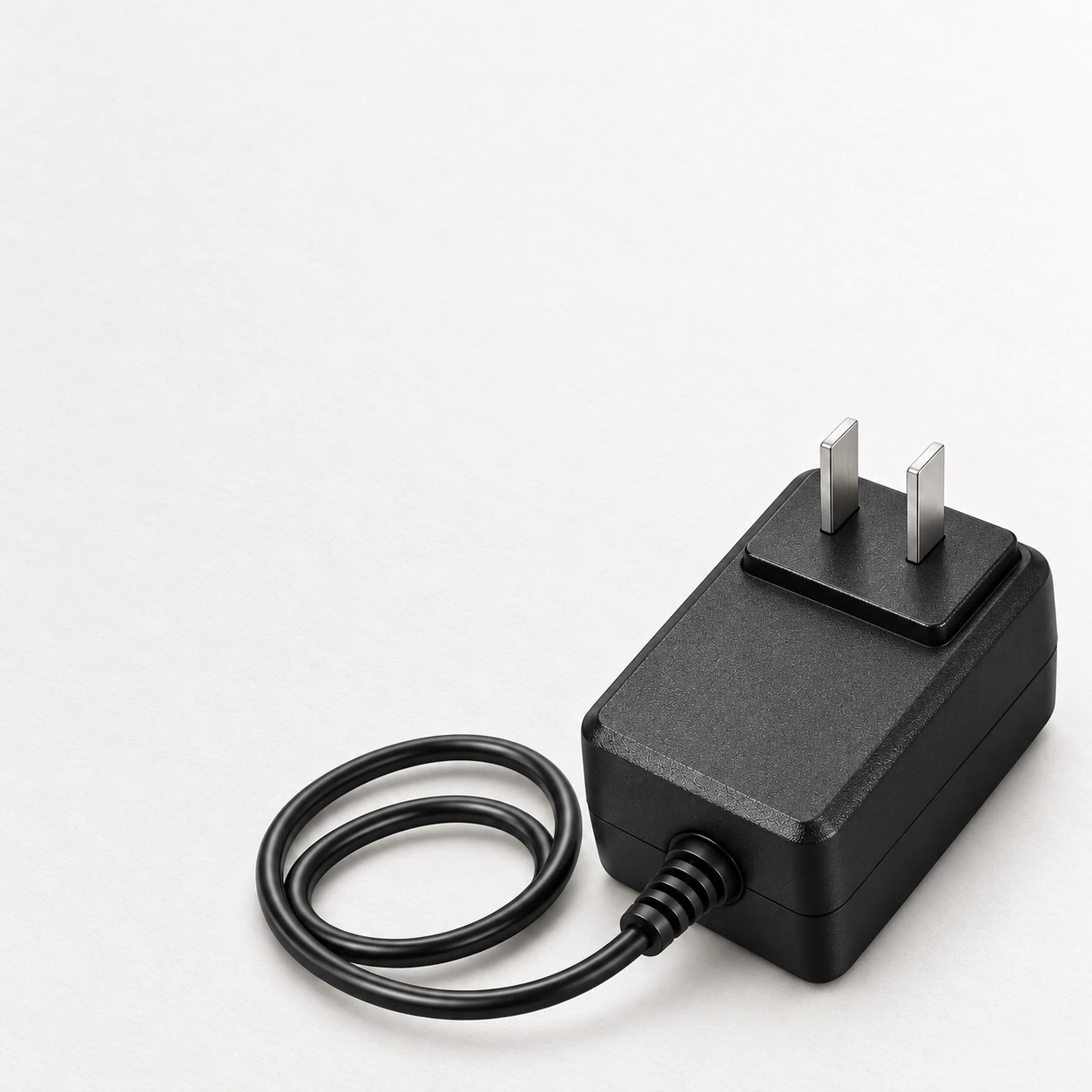 adapter on a plain background, cable coiled to one side